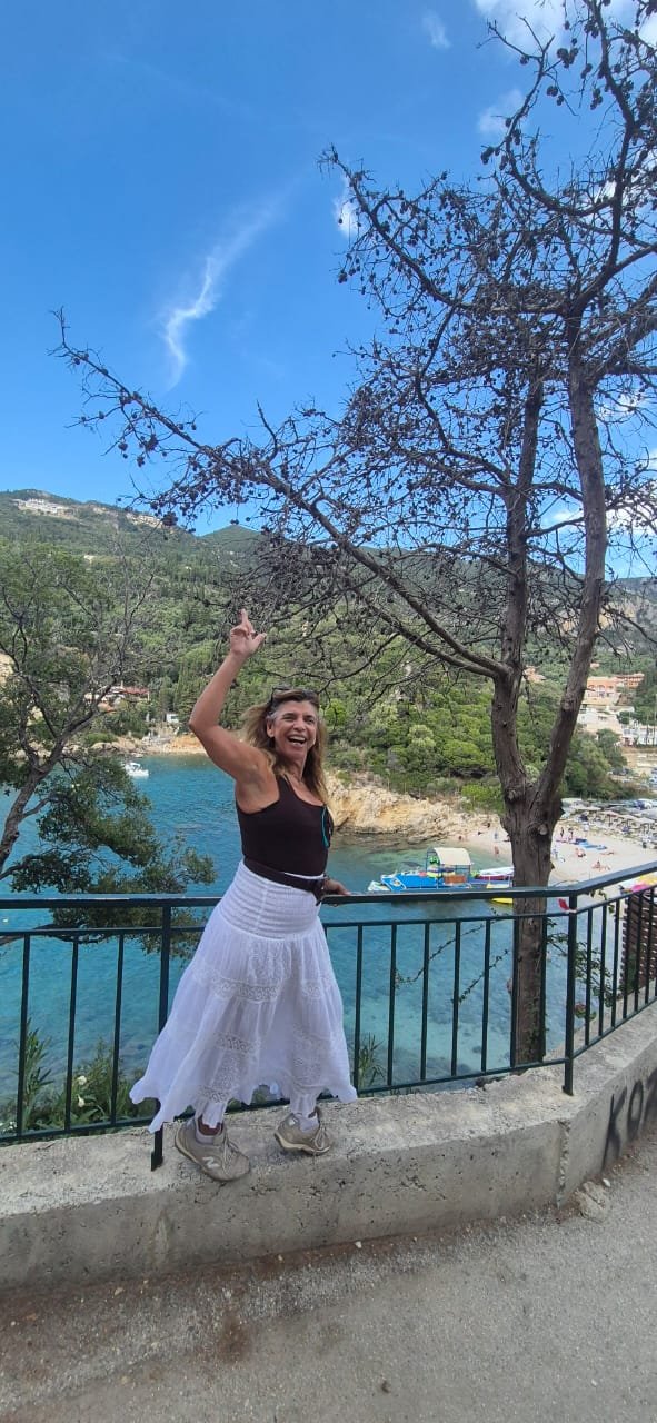 Suyene Uchoa com vista para uma praia de Corfu
